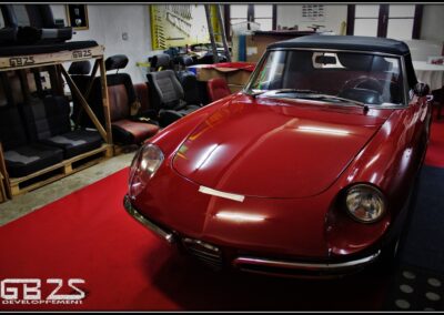 atelier de sellerie avec une Alfa Romeo Duetto Spider au centre